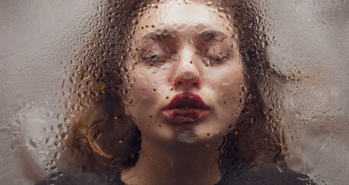 Close-up of woman kissing wet glass with star shape decoration