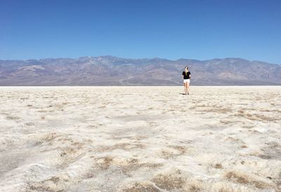 Rear view of woman standing on salt flat at death valley