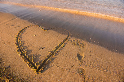 High angle view of heart shape on shore at beach