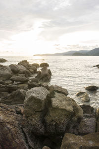 Rock formation on beach against sky