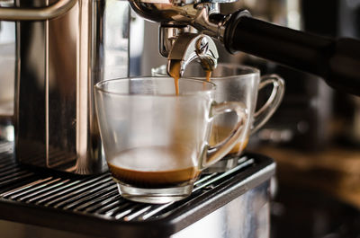 Close-up of coffee maker pouring coffee in cup