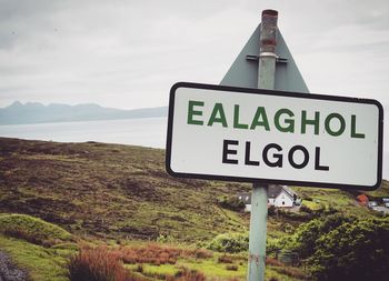 Close-up of road sign on landscape against sky