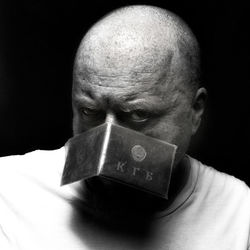 Portrait of man holding camera over black background