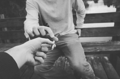 Male friends sharing cigarette