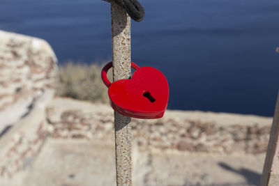 Close-up of red ball hanging on rope at beach