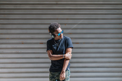 Full length of young man standing against wall