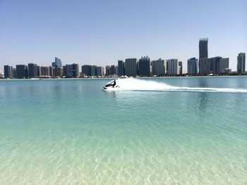 Man jet boating in sea against skyline