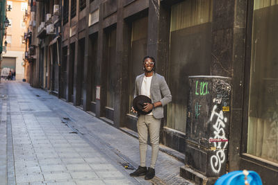 Portrait of man on street against buildings in city