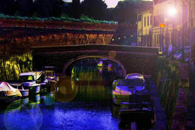 Illuminated bridge over water at night