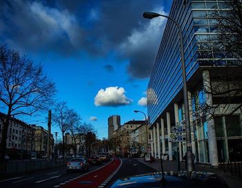 View of city street against cloudy sky