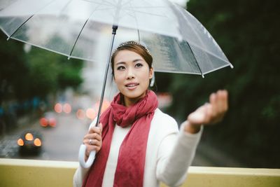 Portrait of beautiful young woman standing in rain