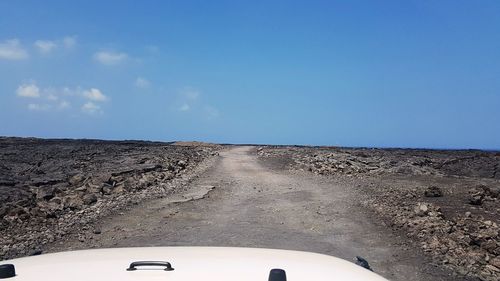 Road against clear sky seen through car windshield