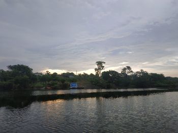 Scenic view of lake by trees against sky