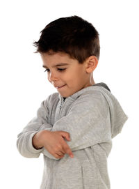 Boy looking away while standing against white background