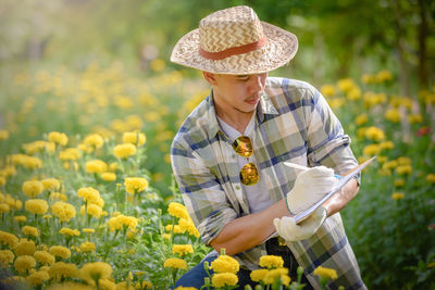 Midsection of person wearing hat on field