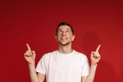 Portrait of young woman gesturing while standing against yellow background