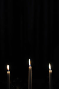 Close-up of burning candle in darkroom