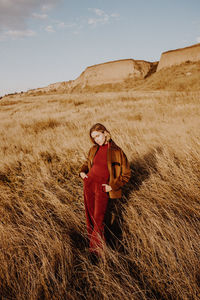 Portrait of woman on field against sky