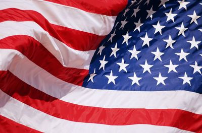 Close-up of american flag against blue sky