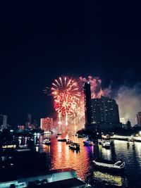 Firework display over illuminated buildings in city at night