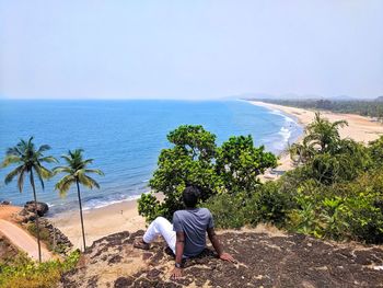 Rear view of a person looking at sea against sky