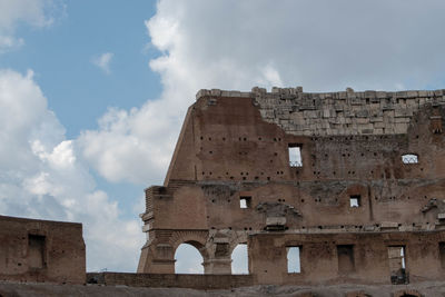 Low angle view of old building against cloudy sky