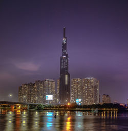 Illuminated buildings against sky at night