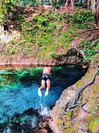 Full length of man on rock against waterfall