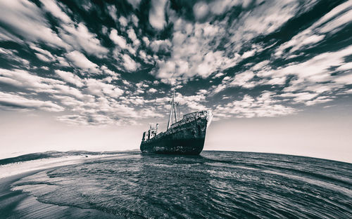 Ship sailing on sea against sky