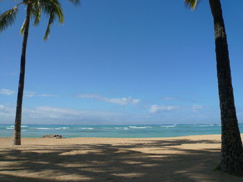 Scenic view of beach against blue sky