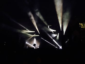 Man playing guitar in concert at night