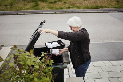 Woman putting rubbish into bin