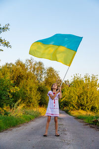 Rear view of woman walking on road