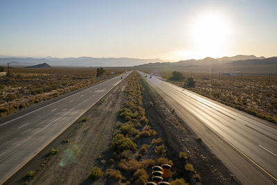 Road amidst landscape against sky during sunset