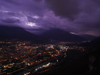 High angle view of illuminated cityscape against sky at night
