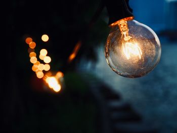 Close-up of illuminated light bulb at night