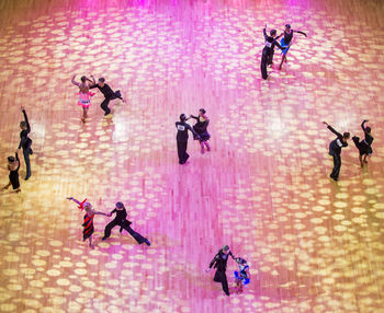 High angle view of people jumping on pink wall