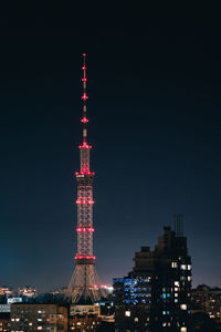 Illuminated buildings in city against sky at night