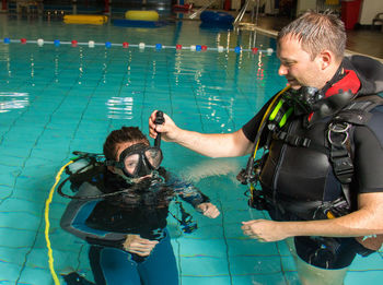 People wearing diving equipment swimming in pool