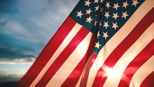 Low angle view of american flag against cloudy sky