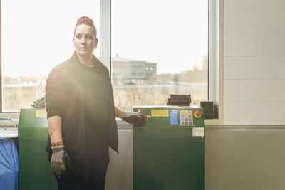 Female mechanic using machine in auto repair shop