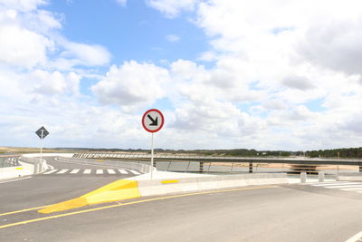 Road sign against sky