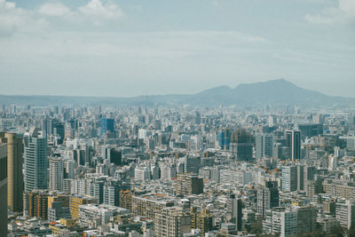 Aerial view of buildings in city against sky