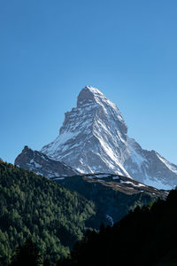 Scenic view of snowcapped mountains against clear blue sky