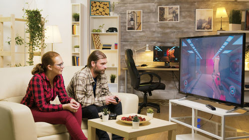 Female friends sitting on sofa at home