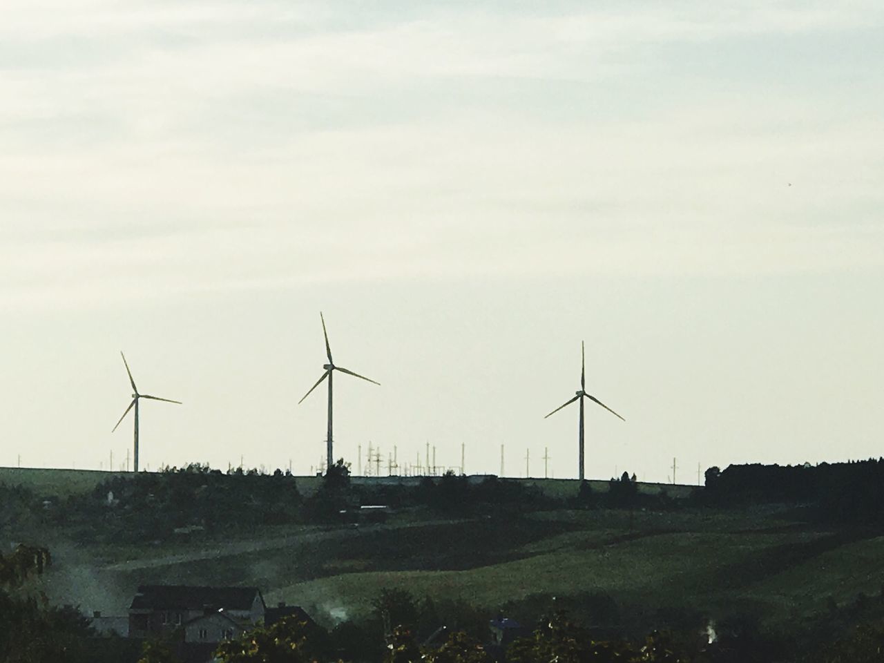 WIND TURBINE ON FIELD AGAINST SKY