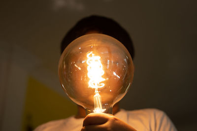 Close-up of hand holding lit candle