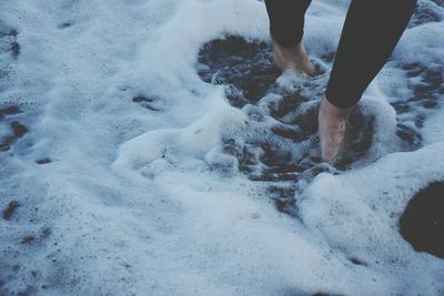 Low section of woman wading in shore