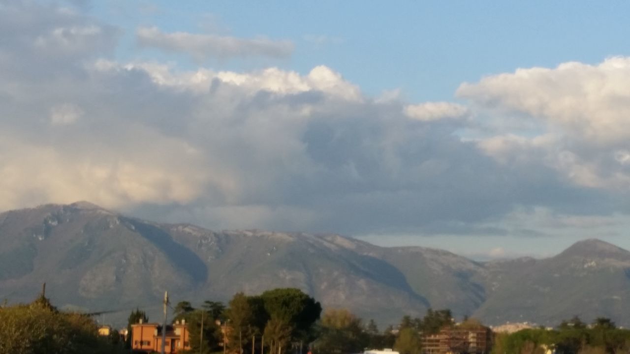 mountain, tree, beauty in nature, sky, mountain range, cloud - sky, nature, scenics, tranquility, built structure, building exterior, tranquil scene, architecture, no people, landscape, outdoors, village, day