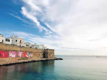Building by sea against sky